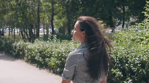 Backside View Long Haired Brunette Girl Walks in Green Park