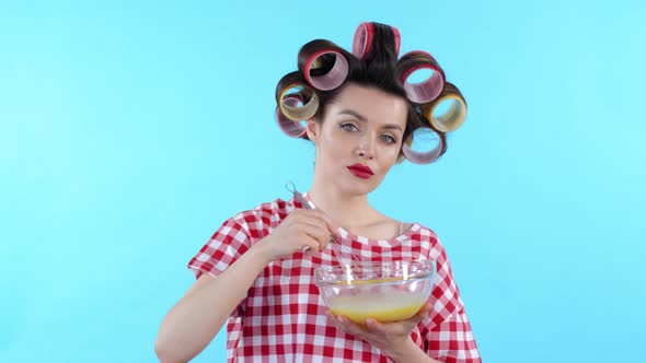 Woman Whisking Egg on Blue Background