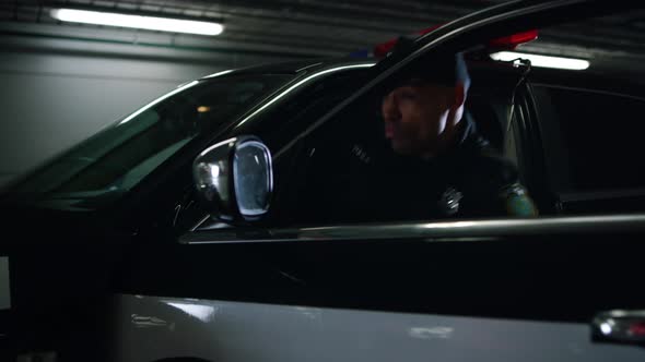 Policemen Sitting in Patrol Car at Underground Parking