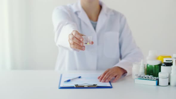 Doctor Showing Medicine Cup with Pills at Hospital