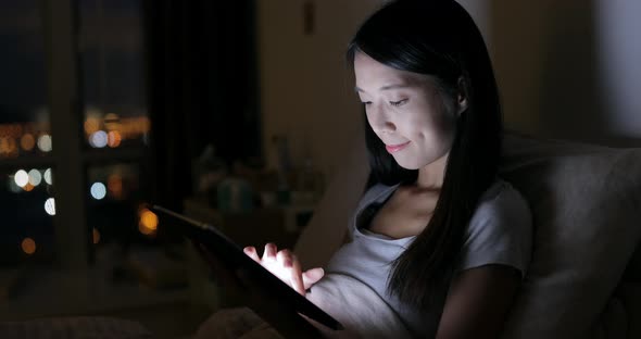 Woman use of tablet computer on bed
