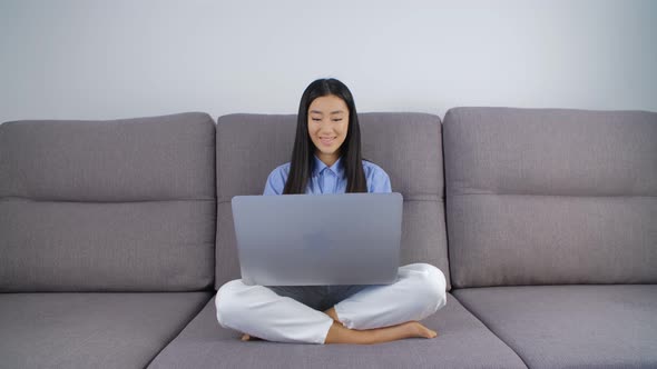 Asian student girl studying online. Young Vietnamese woman working on laptop computer at home