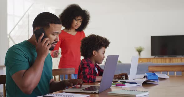 Mother helping son to use laptop at home