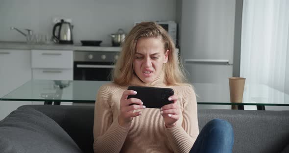 Young Woman Playing Video Games on Her Smartphone and Gets Angry As She Lose the Game