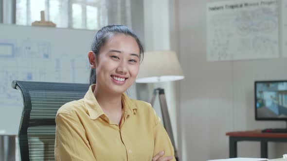 Asian Woman Engineer Posing And Warmly Smiling To Camera At The Office