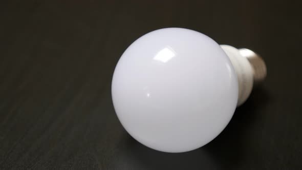 Contemporary LED bulb classic bulbs  alternative on  wooden table slow tilt 4K 2160p 30fps UltraHD f