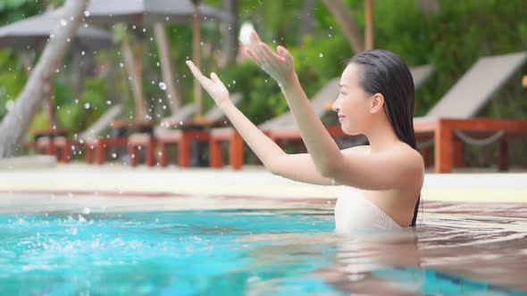 Young asian woman enjoy around outdoor swimming pool for leisure