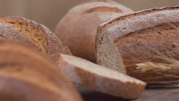 Camera is Zoom Through Sliced and Whole Wheat Bread and Wheat Ears to the Clay Pots