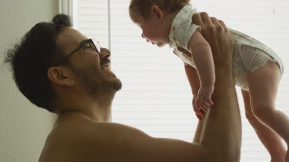 Slow Motion of Man Lifting His Baby Daughter Up at Home