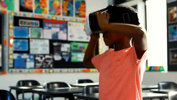 Schoolboy using virtual reality headset in classroom 4k