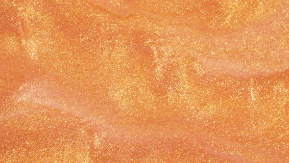 Colorful Golden Sand Organically Moves in Colorful Liquid in Macro