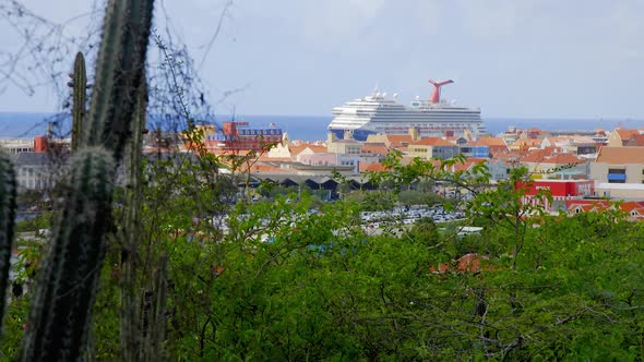 Large cruise ship docked in tropical Caribbean city of Willemstad on the island of Curacao. Wide ang