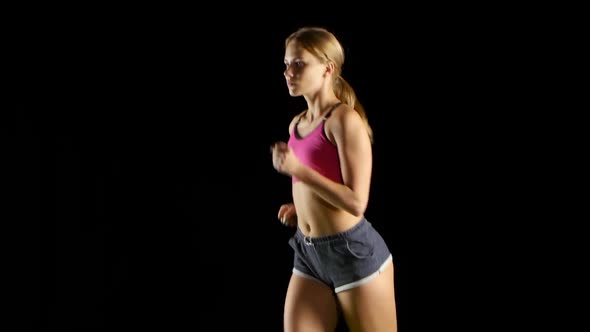 Athlete in Sports Clothes Running Lightly on a Black Screen. Close Up