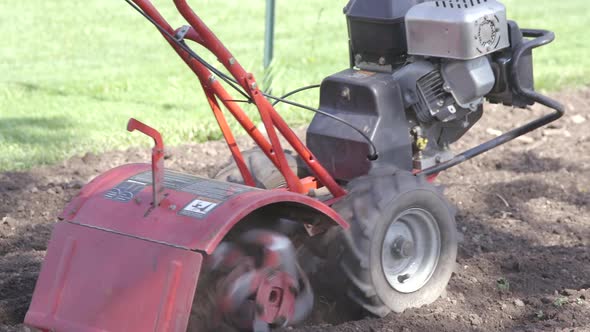 Man tilling the garden in slomo.