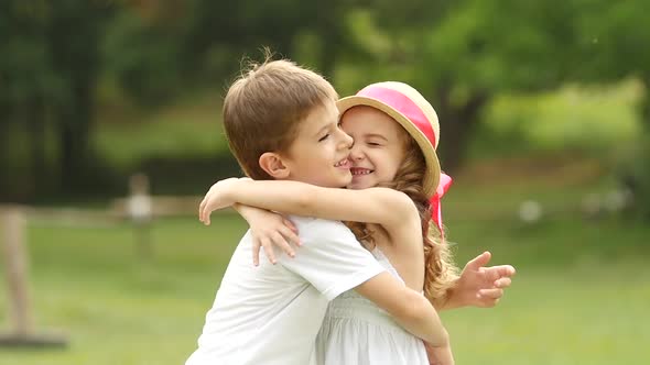 Little Boy Is Gently Hugging the Girl, They Are Happy and Carefree. Slow Motion