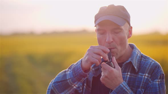 Contented Farmer Smoking His Pipe On Field Wile Examining Crops Agriculture.