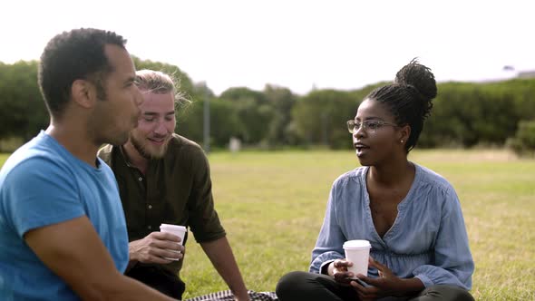 Laughing Colleagues Sitting on Lawn and Laughing.