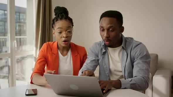 Young Family Recieving Good News in Their Apartment in Front of Their Laptop