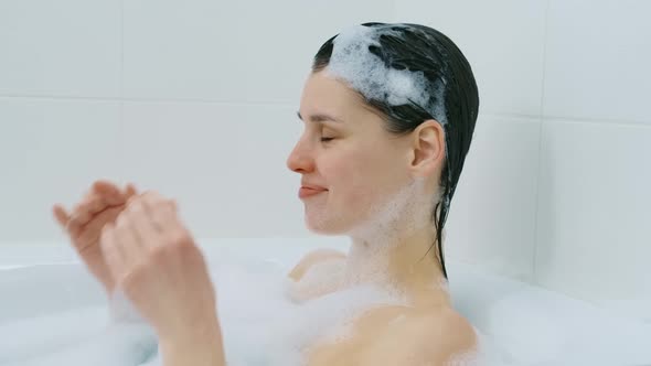 Caucasian Woman Lying Naked in Bath with Foam