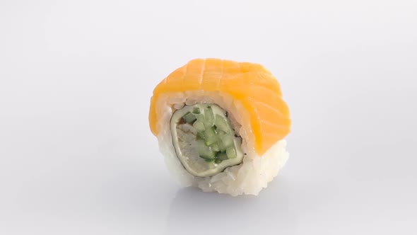 Spinning Sushi Roll with Salmon Isolated on the White Background.