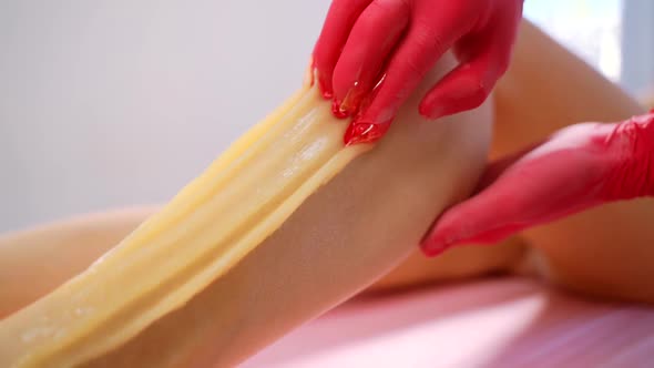 A Female Depilatory Expert Applies Sugar Paste on the Patient's Leg