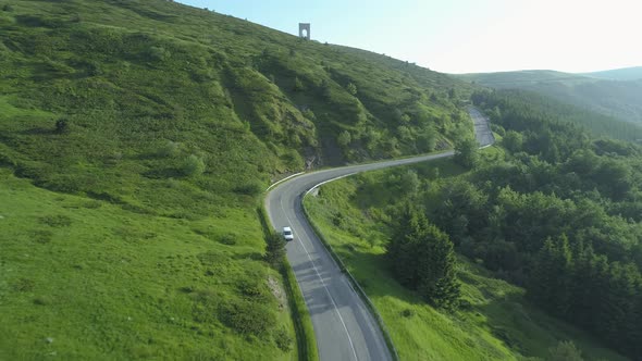 White Car Driving on a Winding Mountain Road