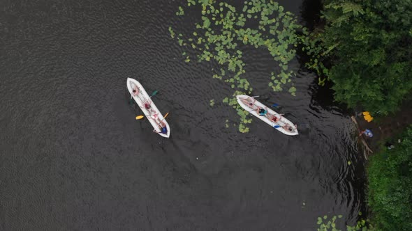 Aerial Birds-Eye View of Two Canoes Filled With People Paddling in a River in the Wilderness