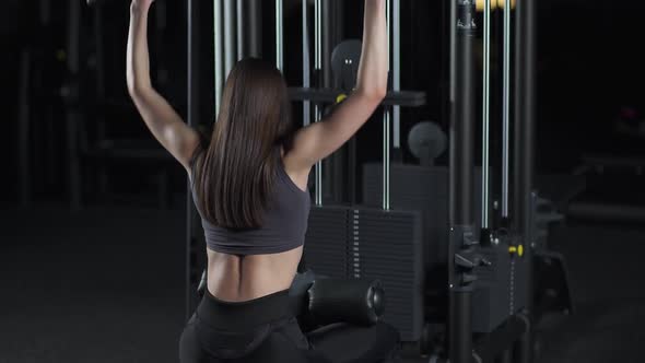 Woman in the Gym Lifting Blocks on Rack Machine Strength Training on Block Device Cinematic Light