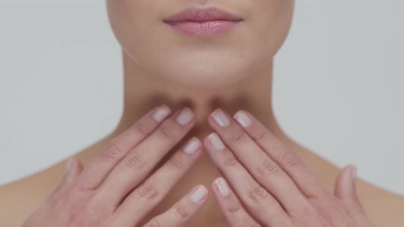 Studio portrait of young, beautiful and natural blond woman applying skin care cream. F