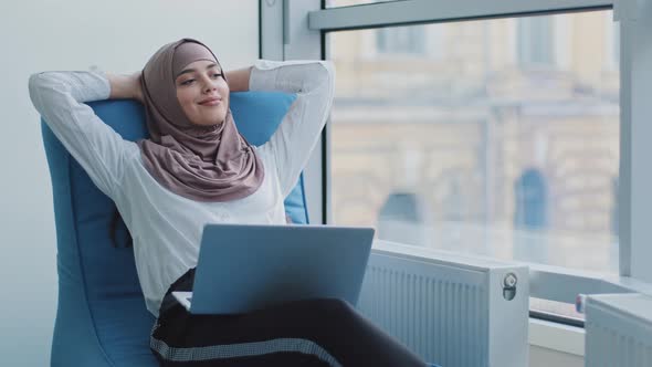 Relaxed Beautiful Muslim Arabic Businesswoman Worker Sits in Comfortable Armchair Meditating