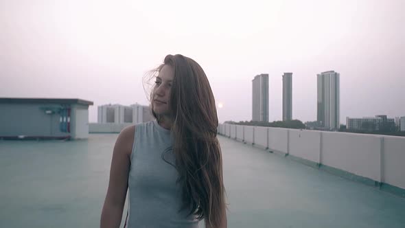 Girl Walks Along Empty Roof Against Sunset Slow Motion