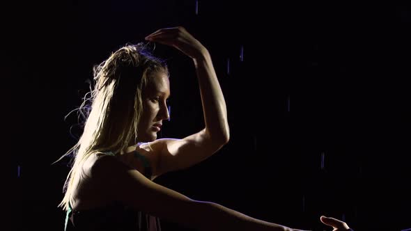 Silhouette of a Pair of Ballroom Dancers Performing an Element of the Latin Dance Bachata on a Black