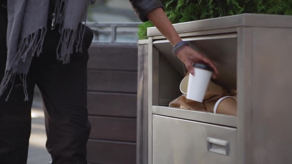 Cropped Image of Stylish Woman in Blue Scarf Throwing Empty Paper Cup to Garbage Can for Paper