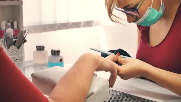 Manicurist Working on Client Nails