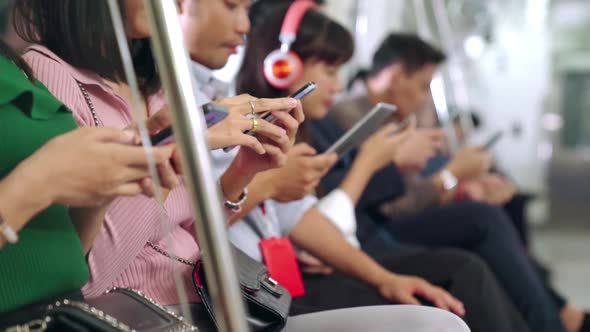 Young People Using Mobile Phone in Public Underground Train