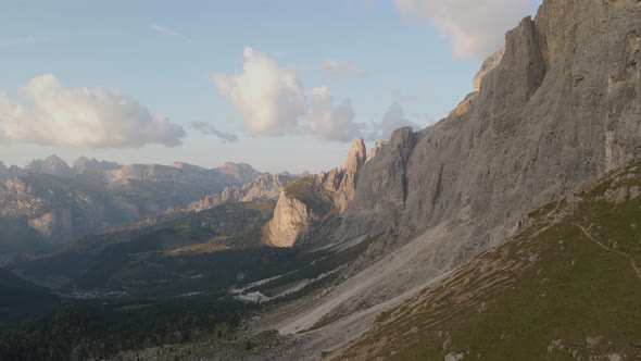 Amazing drone shot of a ruthless and irresistible dolomites mountain range with forests and pastures