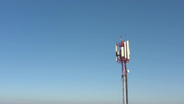 Panels of telecommunication tower against blue sky 4K aerial video