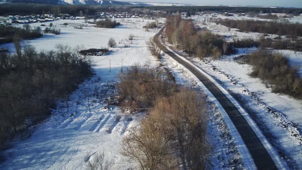 Aerial view of car moving on road in winter season.