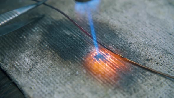 Heating of Wire with Gas Burner on Fireproof Sheet Closeup