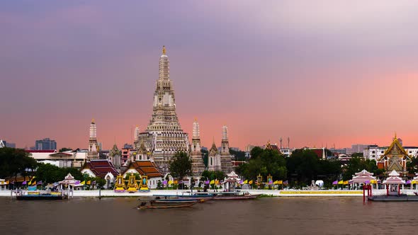 day to night time lapse of Wat Arun Temple with Chao Phraya river in Bangkok, Thailand