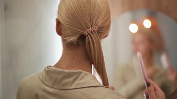 Back view of woman brushing her hair