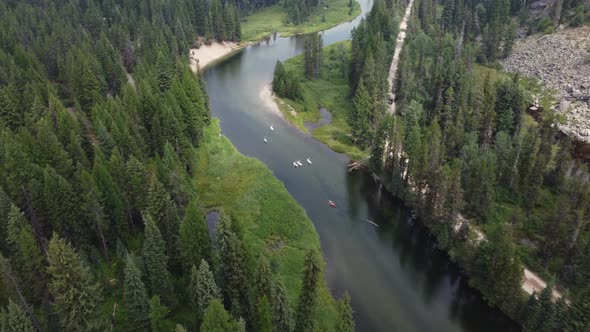 Paddleboarders and kayakers floating on the Payette River in the forest near McCall, Idaho. This stu