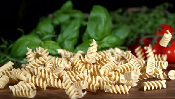 Super Slow Motion Shot of Fresh Fusilli Falling on Italian Decorated Wooden Table at 1000Fps
