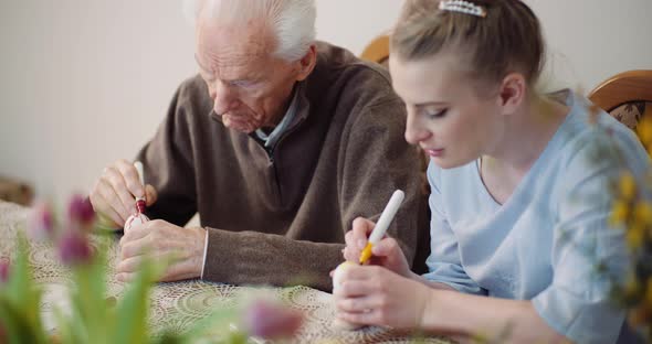 Hands Coloring Easter Eggs with Colors and Brush.