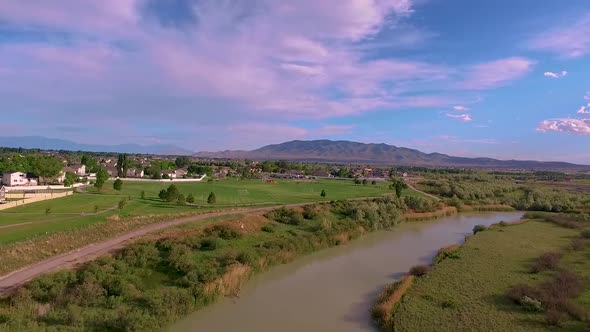 Aerial view of a beautiful river along a bike path with people riding bikes and a highway and a bird