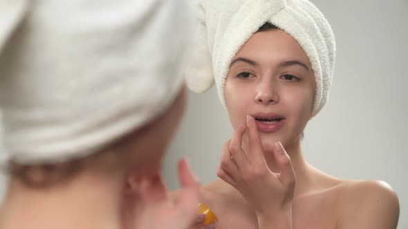 Girl in Towel Using Lip Balm