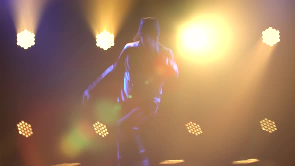 Trendy Young Man Dancing Single in Club, Neon Light, Lots of Smoke. Breakdance Close Up. Silhouette.