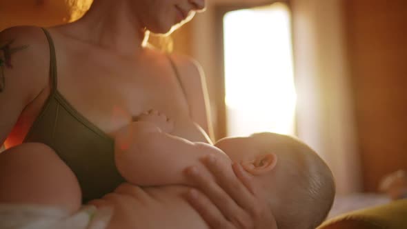 Authentic Close Up Shot of Young Neo Mother is Playing with Her Newborn Baby in a Nursery in a