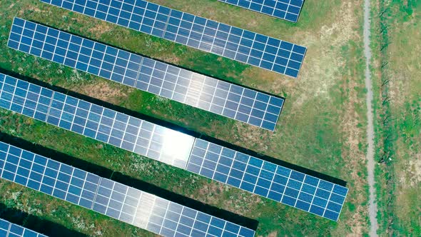 Aerial View. Flying Over The Solar Power Plant With Sun. Solar Panels And Sun.