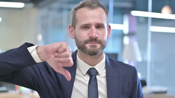 Portrait of Young Businessman Showing Thumbs Down